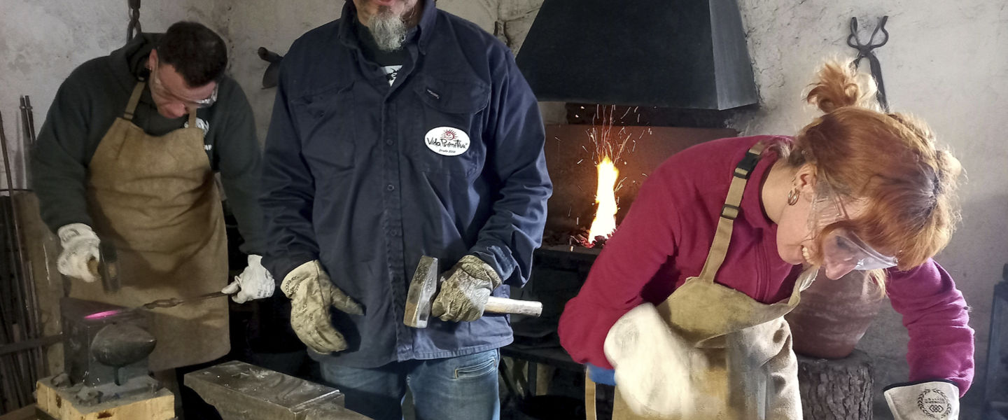 El herrero atendiendo a una pareja. La Fragua Íbera